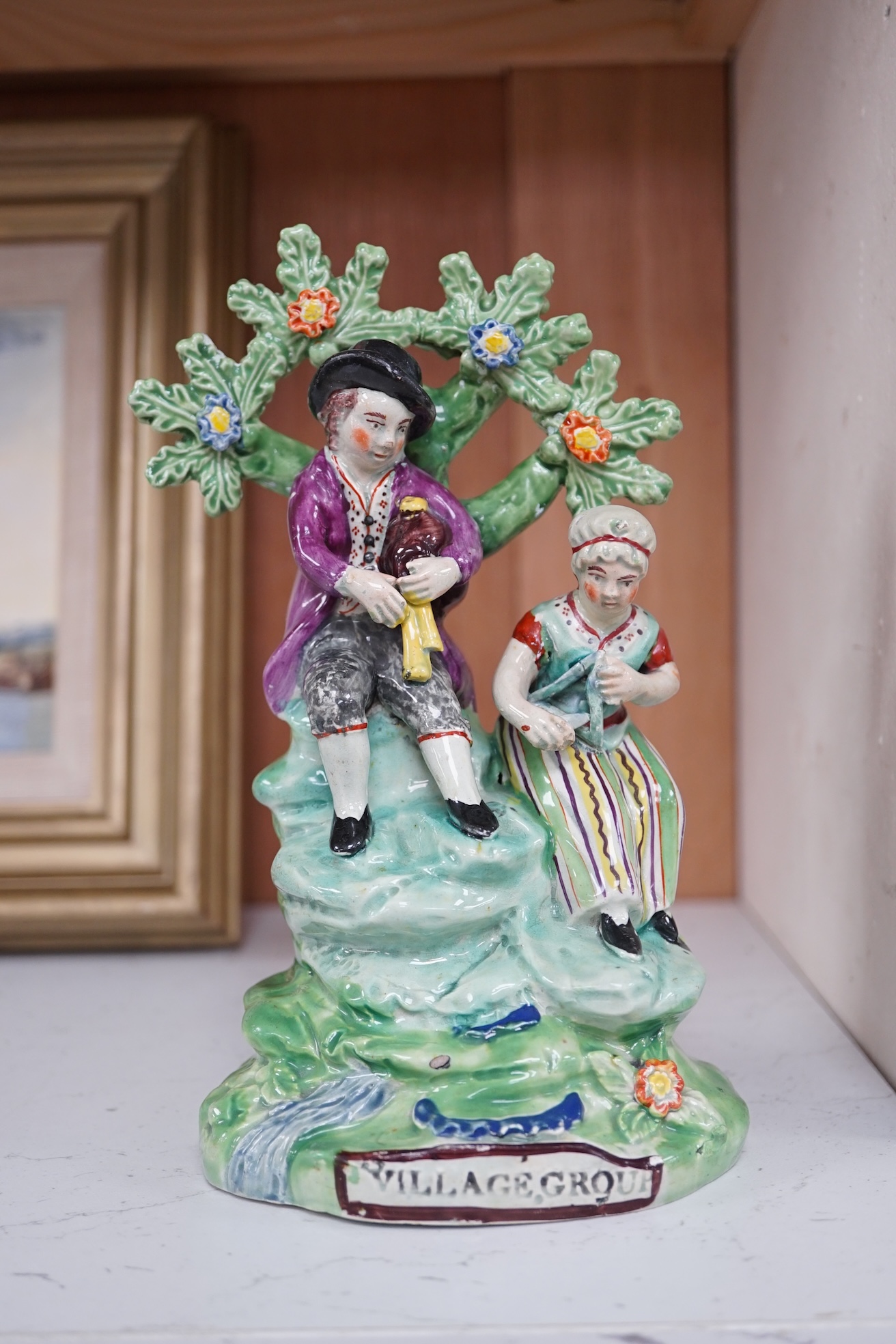 An early 19th century Staffordshire pearlware ‘village group’, 19.5cm high. Condition - fair to good